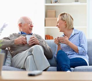 Two elder couples smiling drinking coffee